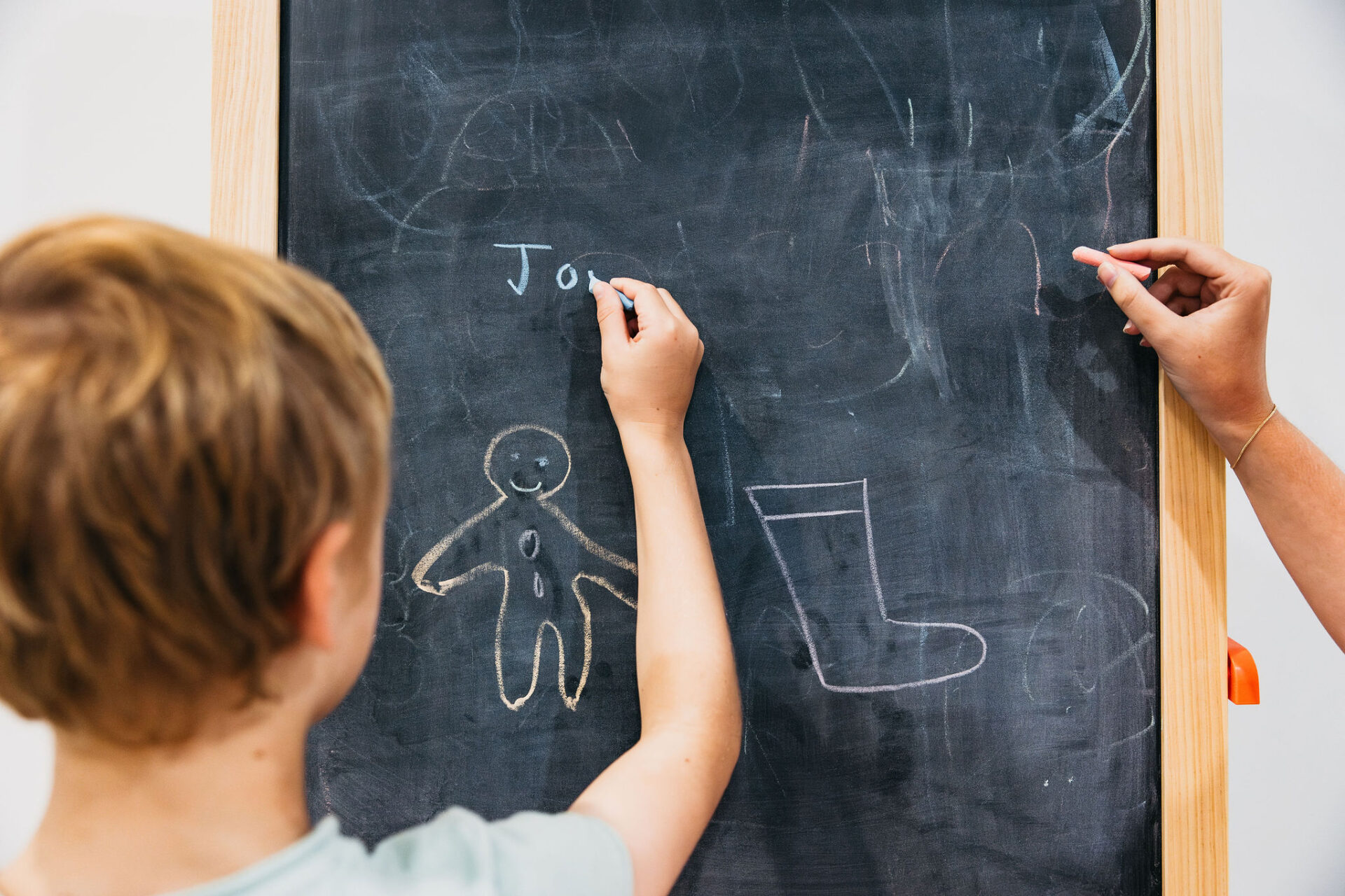 Child practising writing on chalkboard at Norman Park