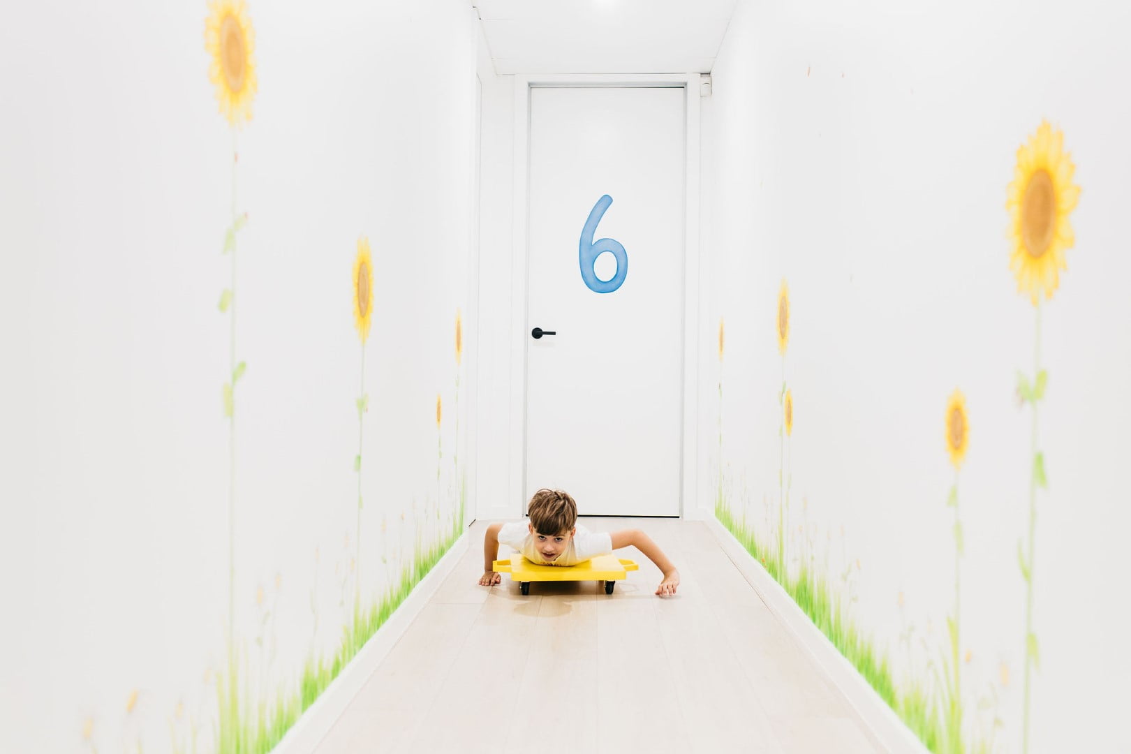 Enhancing Child Development Through Gross Motor Skills: The Role Of Paediatric Occupational Therapy 5 Child pushing themselves on a board